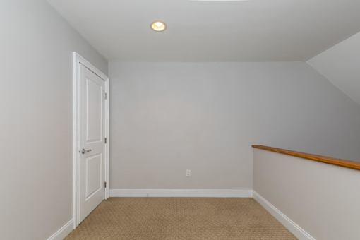 A room with a carpeted floor and a white door.