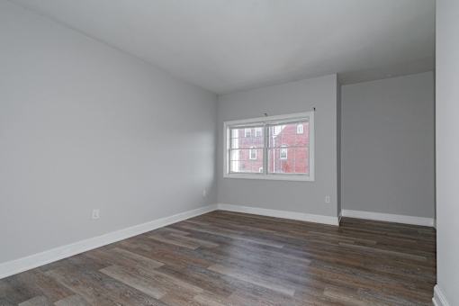 A room with wooden flooring and a window.