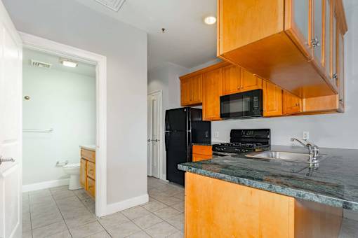 A kitchen with wooden cabinets and a granite countertop.
