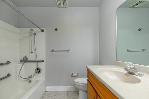 A white bathroom with a toilet, sink, and shower.
