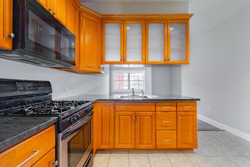 A kitchen with wooden cabinets and black appliances.