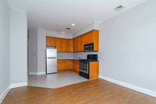 A kitchen with wooden cabinets and a black stove top oven.