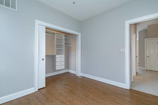 A room with a white door and a white cabinet with drawers.