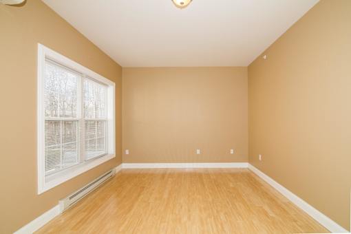 A room with a window and wooden flooring.