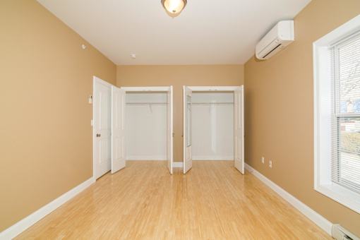 A room with two closets and a window.