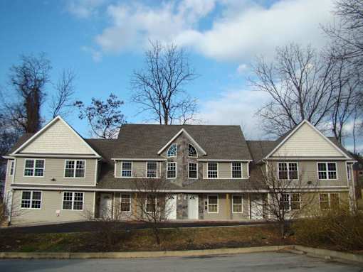 A large, two-story house with a grey and white exterior.