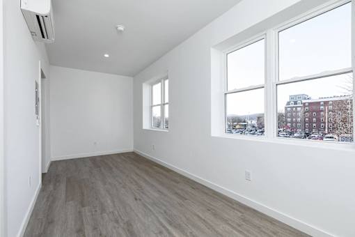 A room with a window and a wall-mounted air conditioner.