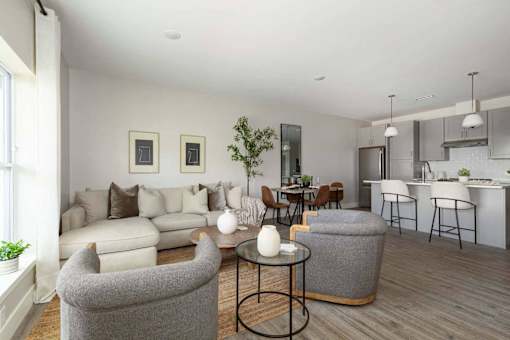 A modern living room with a grey sofa and a glass coffee table.