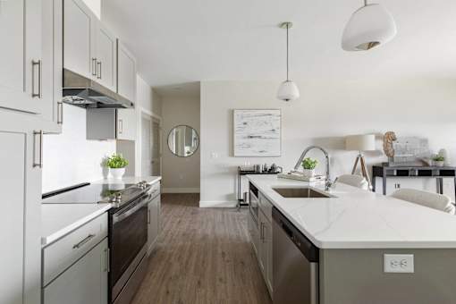 A modern kitchen with a white countertop and stainless steel appliances.