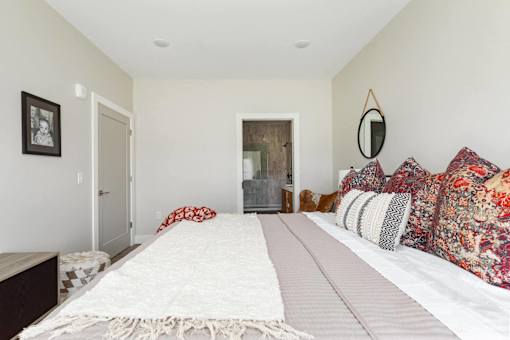 A bedroom with a large bed and a mirror on the wall.