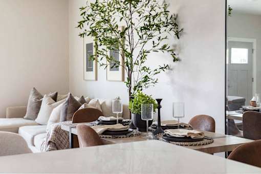 A dining room with a table set for a meal.