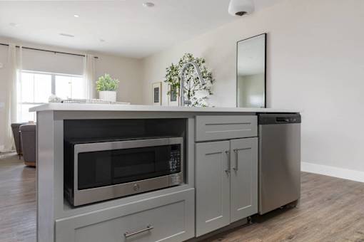 A modern kitchen with a stainless steel oven and microwave.