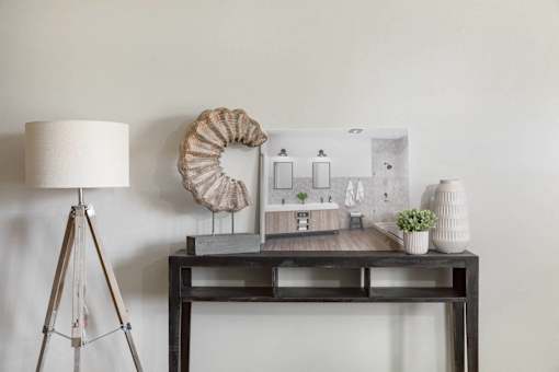 A table with a lamp, a plant, and a model of a house.