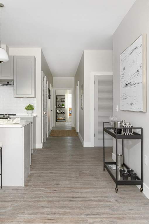 A long hallway with a white sink and a black cart.