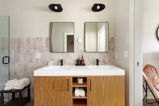 A bathroom with a white sink and a wooden cabinet.