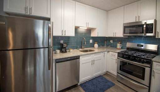 A modern kitchen with a stainless steel refrigerator, microwave, oven, and sink. at Paces Ridge at Vinings, Atlanta