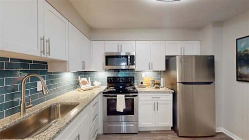 A kitchen with a stainless steel refrigerator, sink, and stove. at Vinings RiverVue, Georgia, 30339