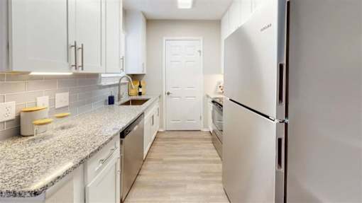 A kitchen with white cabinets and a granite countertop. at Breckinridge Vue, Duluth, Georgia