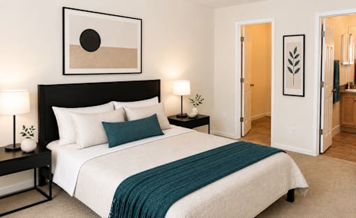 A bedroom with a large bed and a painting above it.