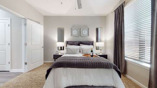 A bedroom with a bed, two lamps, and a clock on the wall at Embry Hills, GA, 30042