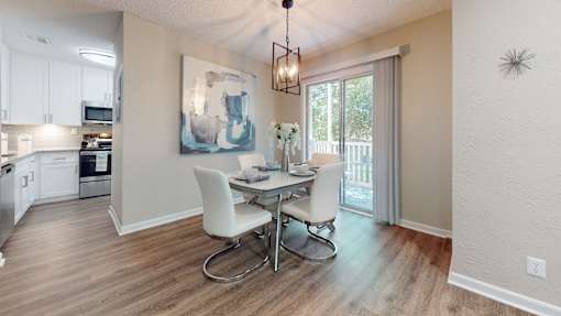 A dining room with a table and chairs.