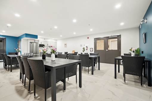 A modern dining room with a large table and chairs.