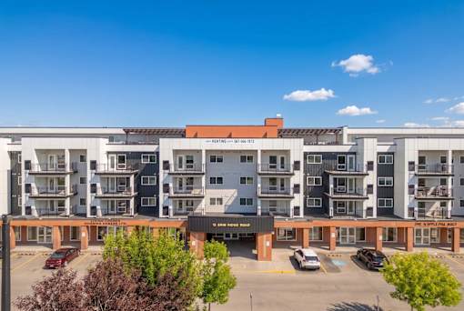 A large multi-story apartment building with a parking lot in front.