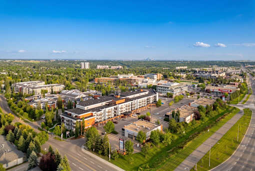 A cityscape with buildings, roads, and trees under a clear sky.