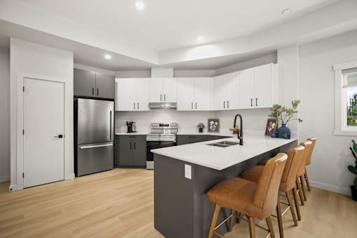 A modern kitchen with a large island and wooden floors.