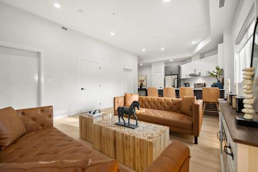 A living room with brown leather sofas and a wooden coffee table.