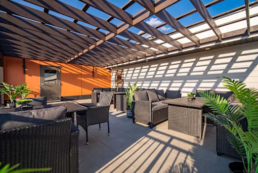 A patio with a table and chairs under a roof.