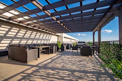 A patio with a table and chairs under a roof.