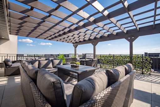 A patio with a table and chairs under a pergola.