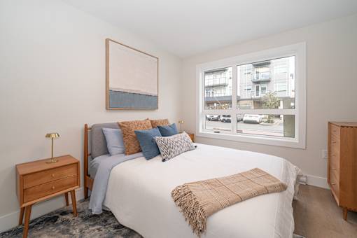 Bedroom with a Large Bed at Woodland Place Apartments, Langford, British Columbia