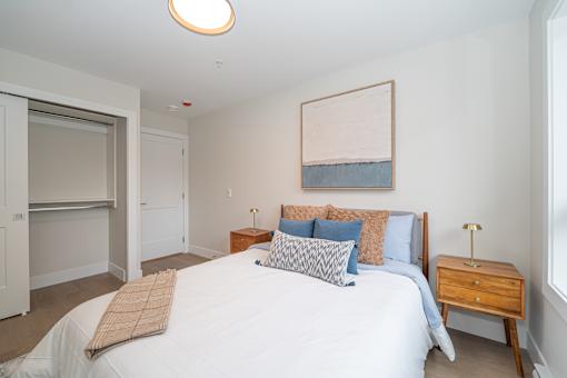 Bedroom with a Painting on the Wall at Woodland Place Apartments, Langford, BC