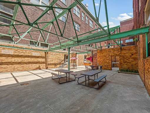 A patio with a table and chairs under a green canopy.