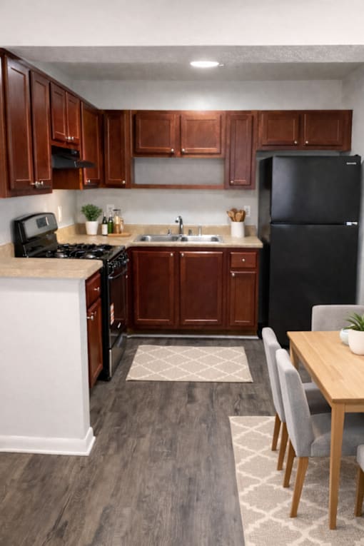 A kitchen with wooden cabinets and a black refrigerator.
