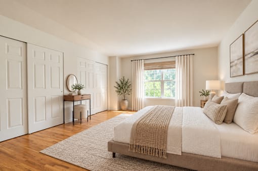 A bedroom with a large bed and a desk with a chair.