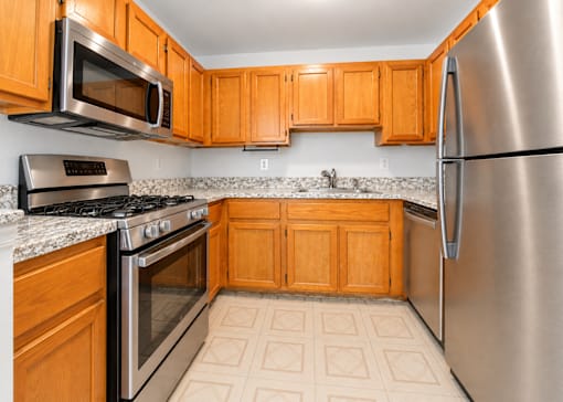 A kitchen with wooden cabinets and stainless steel appliances.