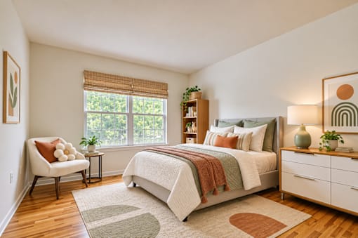 A bedroom with a large bed, a chair, and a window with blinds.