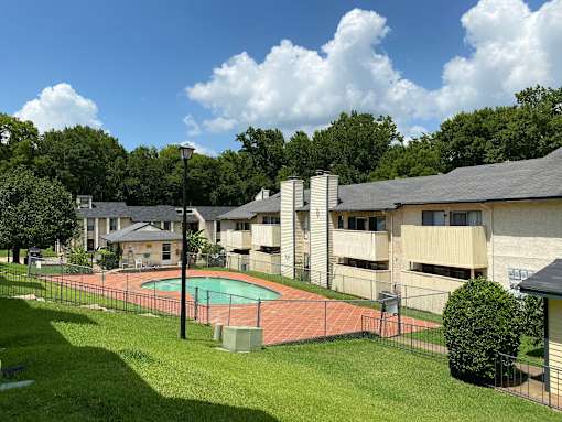 A pool surrounded by a fence in a grassy area.
