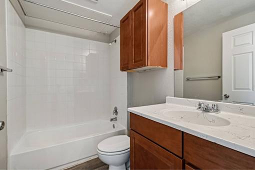 A white bathroom with a toilet, sink, and bathtub.