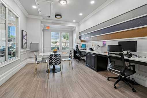 A modern office space with wood flooring and a variety of chairs and desks.