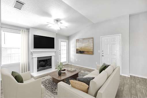 A living room with a fireplace, a television, and a painting.