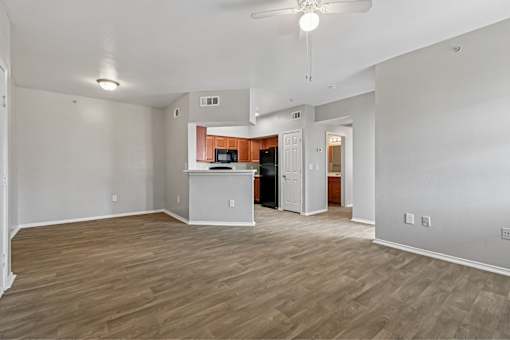 A spacious living room with wood flooring and a ceiling fan.