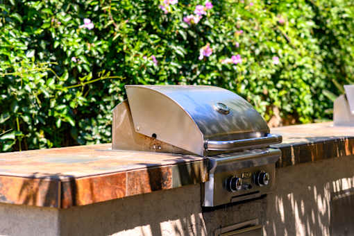 A stainless steel grill with a lid on it.