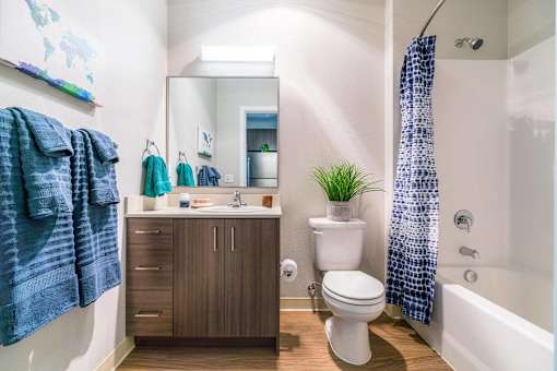 A bathroom with a toilet, sink, and a shower curtain.