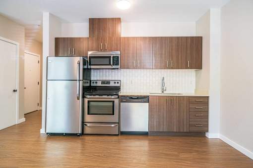 A kitchen with a refrigerator, oven, microwave, and dishwasher.