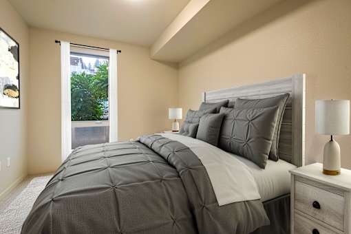 A bedroom with a large bed and a window overlooking a tree.