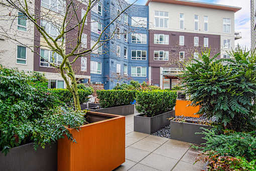 A modern outdoor seating area with a bench and a planter box.
